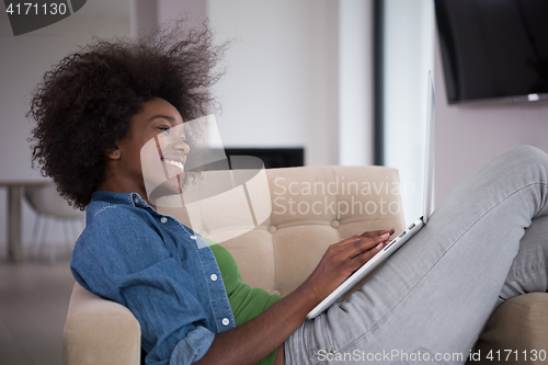 Image of African American women at home in the chair using a laptop