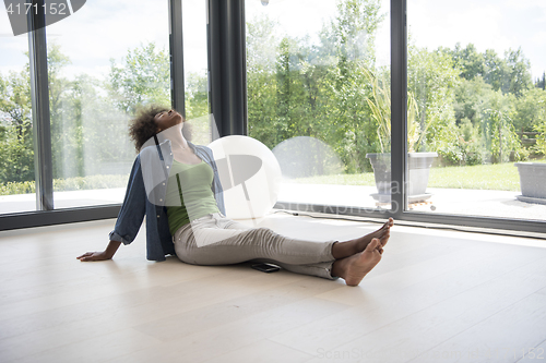 Image of african american  woman  sitting near window