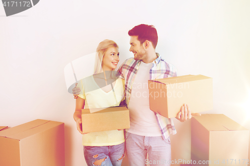 Image of smiling couple with big boxes moving to new home