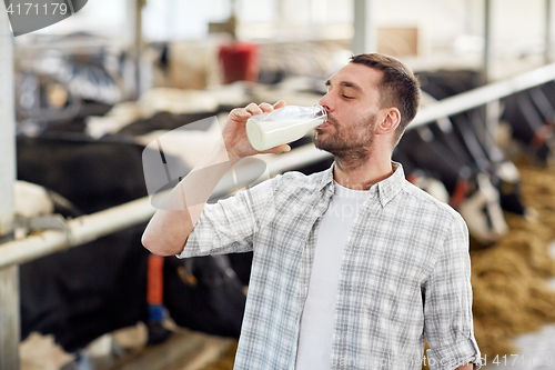 Image of man or farmer drinking cows milk on dairy farm