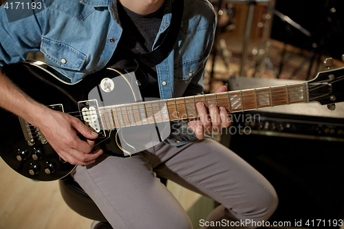 Image of man playing guitar at studio rehearsal