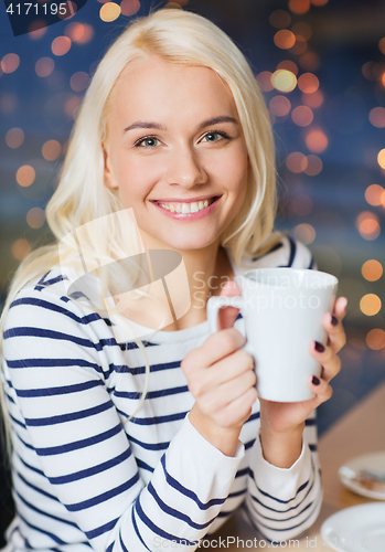 Image of happy young woman with tea or coffee cup