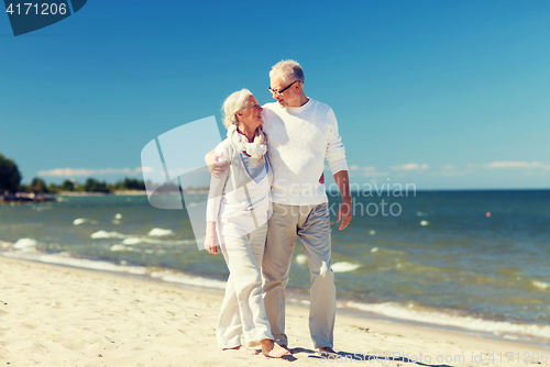 Image of happy senior couple hugging on summer beach