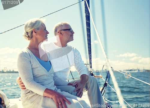 Image of senior couple hugging on sail boat or yacht in sea