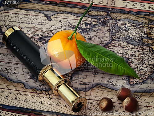 Image of vintage telescope and mandarine at antique map