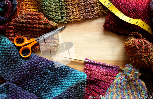 Image of Border of knitting, wool, craft scissors and tape measure