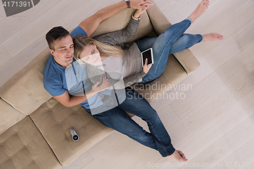 Image of youg couple in living room with tablet top view