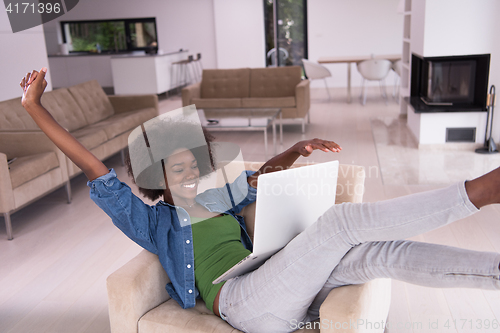 Image of African American women at home in the chair using a laptop