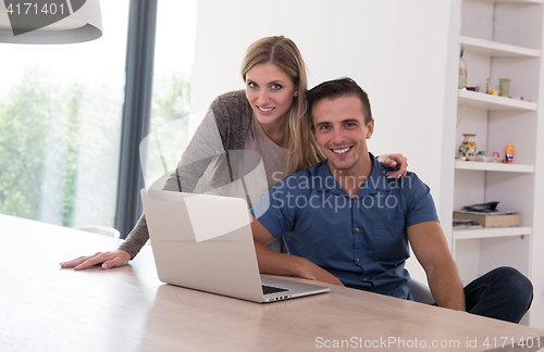 Image of couple using laptop at home