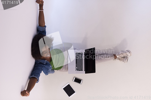 Image of african american woman sitting on floor with laptop top view