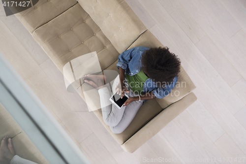 Image of african american woman at home with digital tablet top view