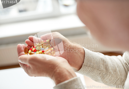 Image of close up of old man hands holding medicine