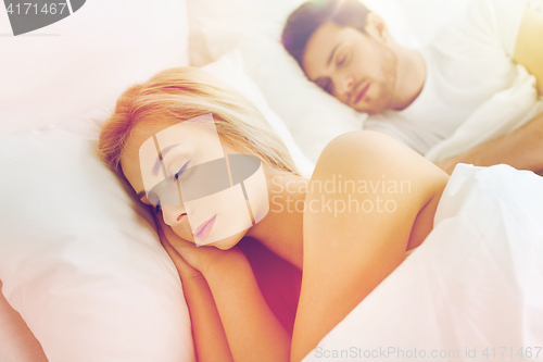 Image of happy couple sleeping in bed at home