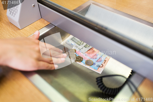 Image of hand with cash money at bank office or exchanger