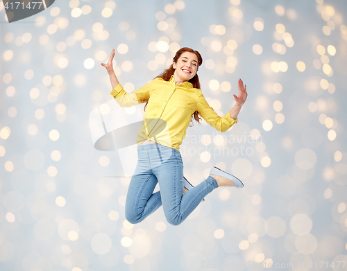 Image of smiling young woman jumping in air