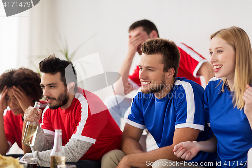 Image of friends or football fans watching soccer at home