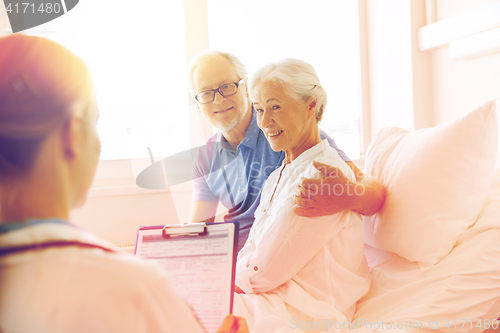 Image of senior woman and doctor with clipboard at hospital