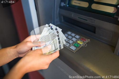 Image of close up of hand withdrawing money at atm machine