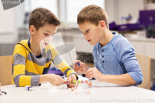 Image of happy children building robots at robotics school