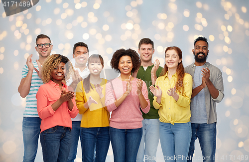 Image of international group of happy people applauding