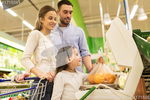 Image of family weighing oranges on scale at grocery store