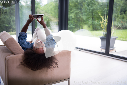 Image of african american woman at home with digital tablet