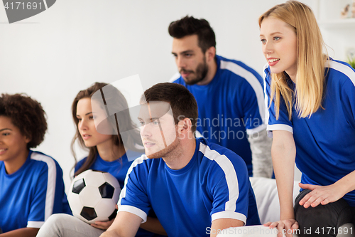 Image of friends or football fans watching soccer at home