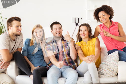 Image of happy friends taking selfie by smartphone at home