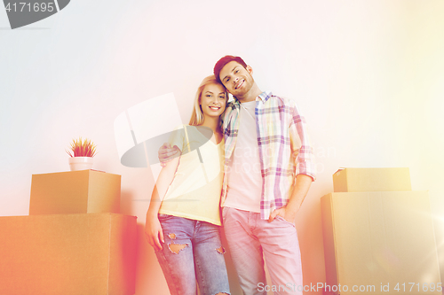 Image of smiling couple with big boxes moving to new home