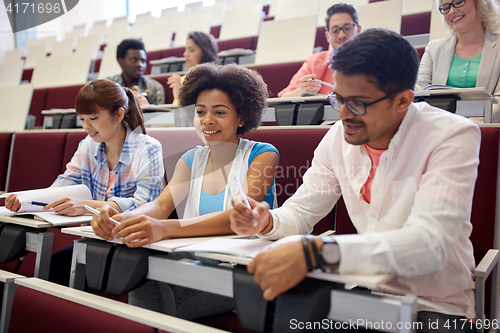 Image of group of students with notebooks in lecture hall