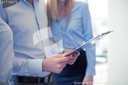 Image of close up of business team looking at clipboard