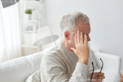 Image of senior man suffering from headache at home