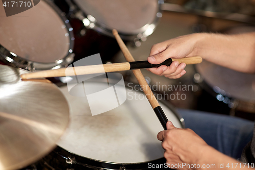 Image of male musician playing drums and cymbals at concert