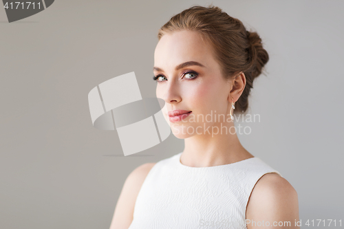 Image of smiling woman in white dress with diamond jewelry