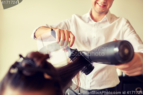 Image of  close up of stylist making hairdo at salon