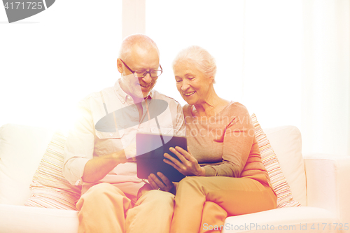 Image of happy senior couple with tablet pc at home