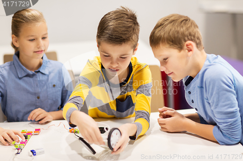 Image of happy children building robots at robotics school