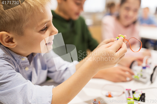 Image of close up of boy building robot at robotics school