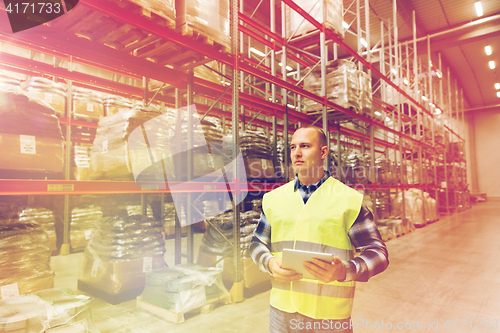 Image of manual worker with tablet pc at warehouse