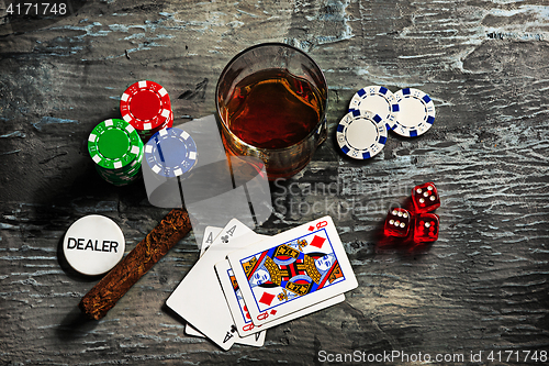 Image of Cigar, chips for gamblings, drink and playing cards