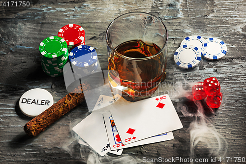 Image of Cigar, chips for gamblings, drink and playing cards