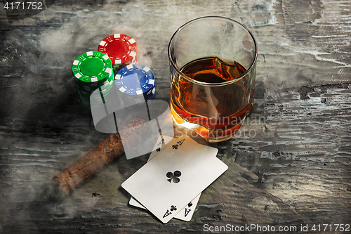 Image of Cigar, chips for gamblings, drink and playing cards