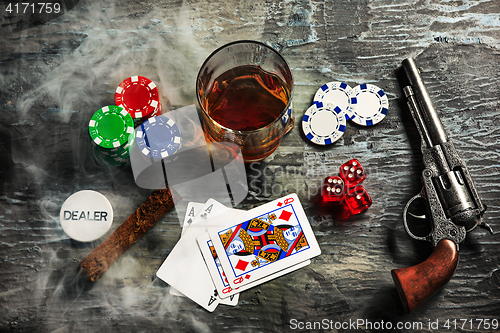 Image of Cigar, chips for gamblings, drink and playing cards