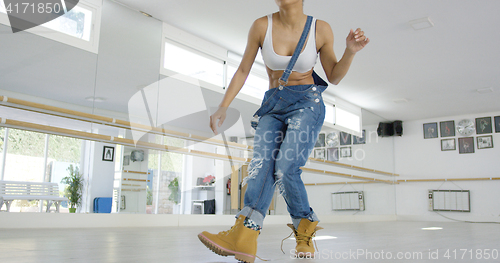 Image of Woman in work boots and overalls dancing