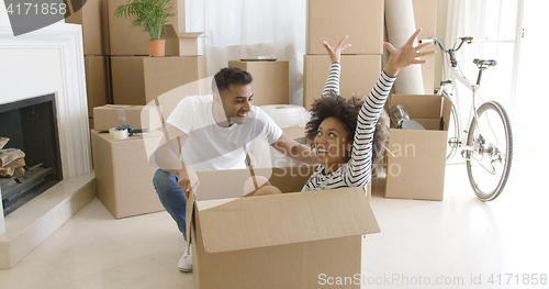 Image of Happy mixed race couple having fun break with unpacking