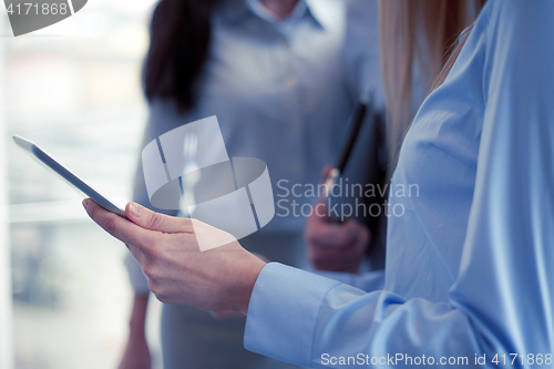 Image of close up of business team with tablet pc in office