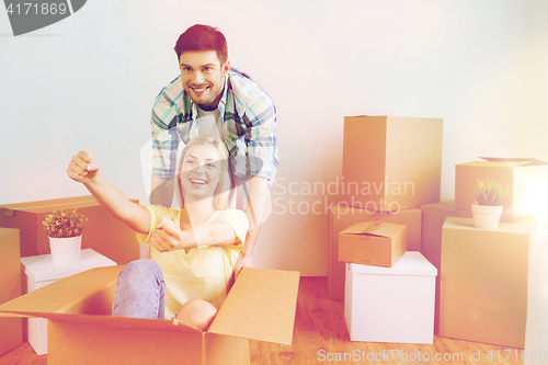 Image of happy couple having fun with boxes at new home