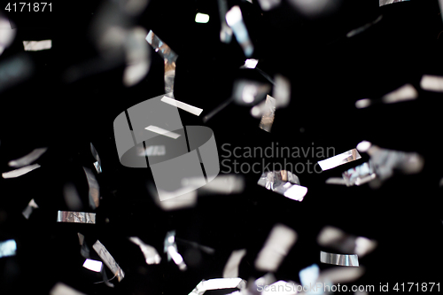 Image of silver confetti over black background