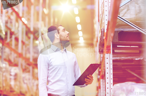 Image of happy businessman with clipboard at warehouse