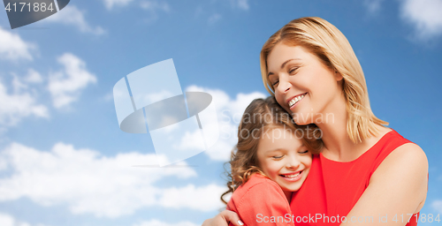 Image of happy mother and daughter hugging over blue sky